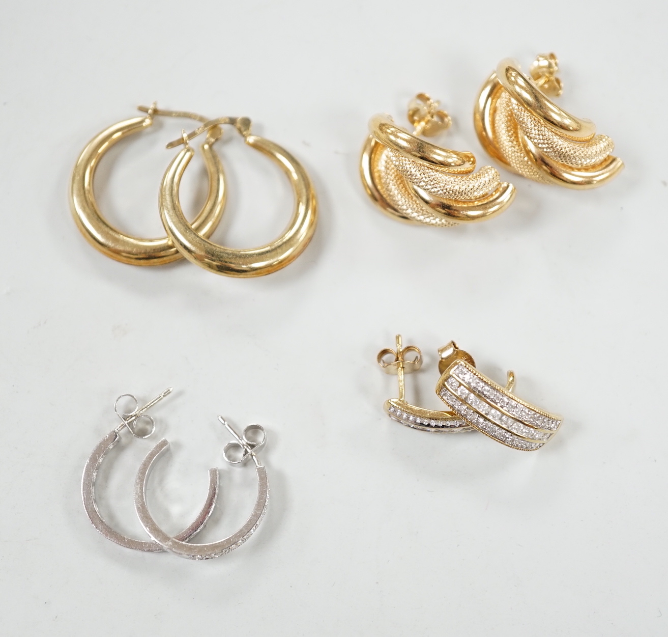 Two modern pairs of 9ct hoop or half hoop earrings and two pairs of 9ct and diamond chip set earrings including white gold, gross weight 10.9 grams.